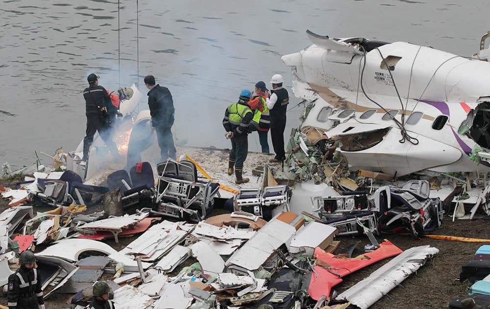 Emergency teams break down pieces of wreckage at the site of a commercial plane crash in Taipei, Taiwan.