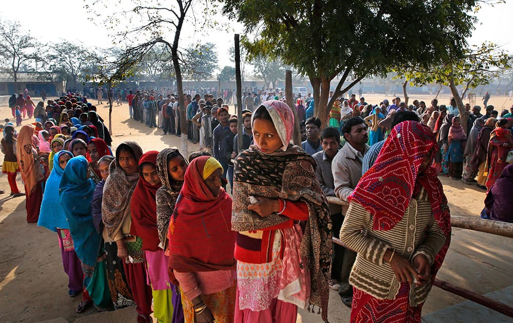 People wait in a queue to cast their votes at a polling booth in New Delhi.