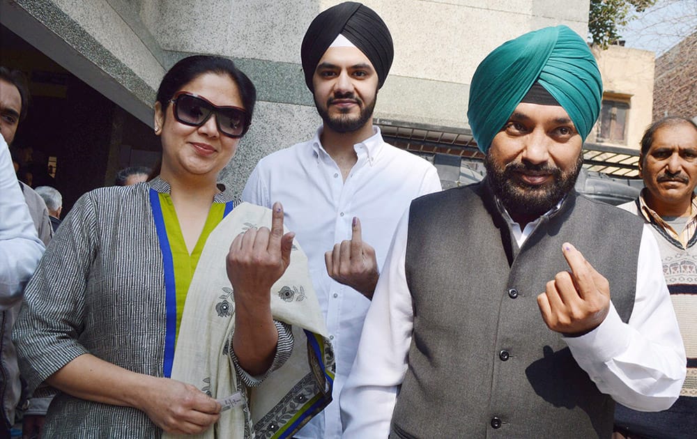DPCC President Arvinder Singh Lovely along with family members shows inked finger after casting votes during the assembly elections in New Delhi.