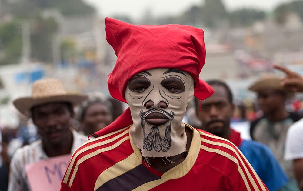 A masked demonstrator attends an anti-government protest in Port-au-Prince, Haiti.