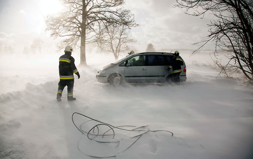 Firemen salvage a motorist stranded by a blizzard on a road near Zalaszentbalazs, 214 kms southwest of Budapest, Hungary.