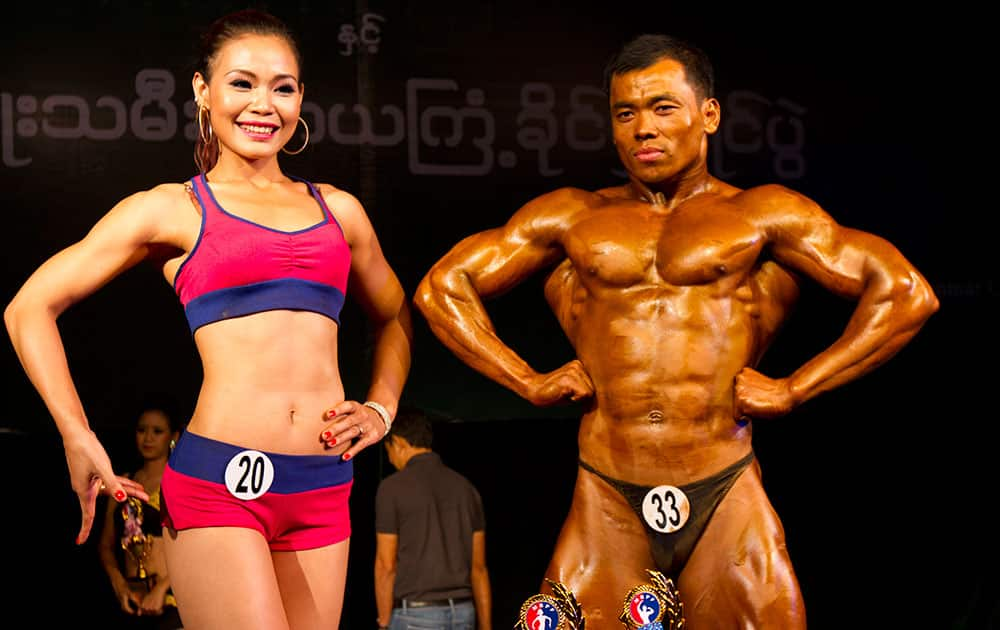 Cherry Maung, left, winner of the model physique and fitness physique contest, poses with Zaw Lin, winner of the bodybuilding contest organized by Myanmar bodybuilder Federation at Myanmar Convention Center (MCC), in Yangon, Myanmar.