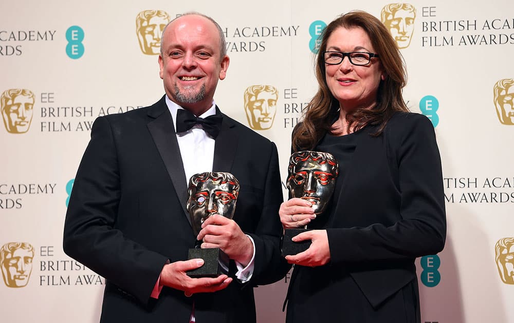 Mark Coulier, left, and Frances Hannon, winners of Best Make-Up and Hair for The Grand Budapest Hotel pose for photographers in the winners room, during the British Academy Film and Television Awards 2015.