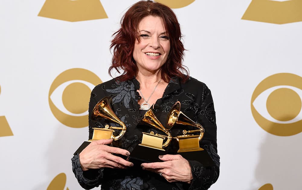 Rosanne Cash poses in the press room with the awards for best American roots performance for “A Feather's Not A Bird”, best American roots song for “A Feather's Not A Bird” and best Americana album for “The River & The Thread” at the 57th annual Grammy Awards.