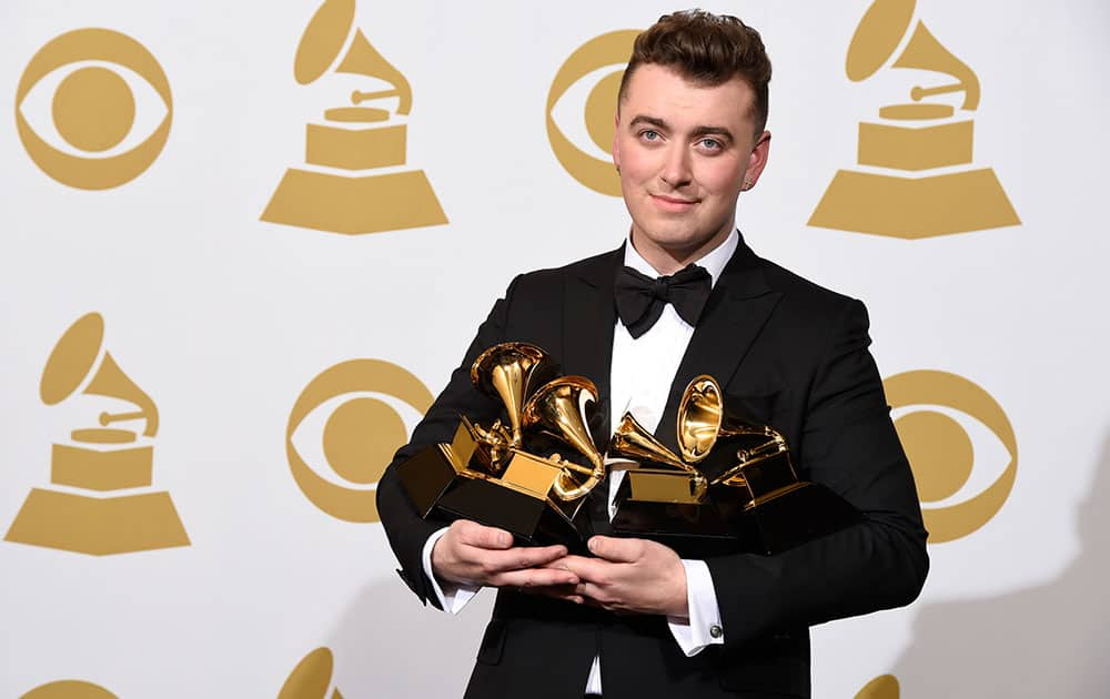 Sam Smith poses in the press room with the awards for best new artist, best pop vocal album for “In the Lonely Hour”, song of the year for “Stay With Me”, and record of the year for “Stay With Me” at the 57th annual Grammy Awards.