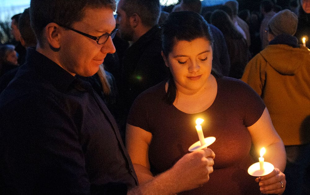 Benjamin Yunker, left, and Brittany Yunker hold candles during a vigil in support of John Dehlin, in North Logan, Utah.