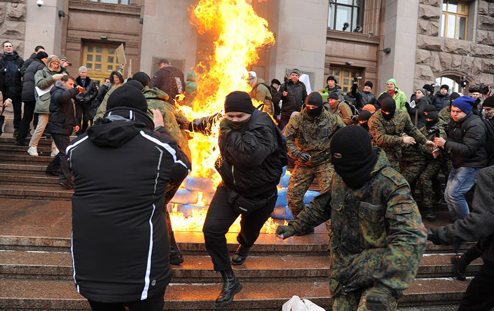 Ukrainian protesters burn tyres outside the city council building as they protest against raising the public transport rates in Kiev, Ukraine.