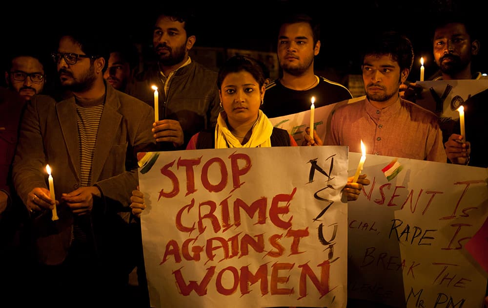 Youth hold candles during a protest against sexual violence in New Delhi. Police were searching Monday for a man who raped a Japanese student sightseeing in northern India, while elsewhere they announced the arrest of eight men suspected of brutally raping and killing a Nepalese woman, as India authorities continue to struggle to address chronic sexual violence.