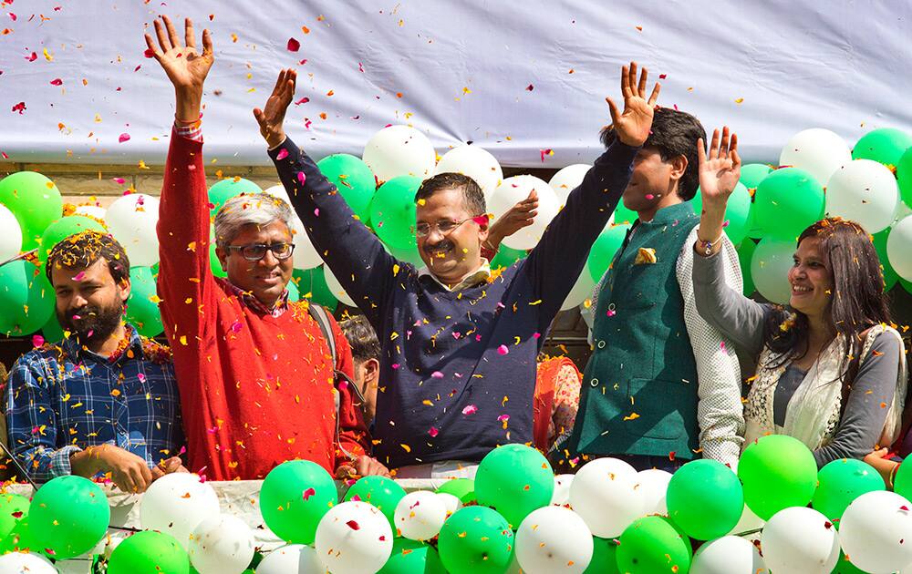 Leader of the Aam Aadmi Party, Arvind Kejriwal, waves to the crowd as his party looks set for a landslide party in New Delhi.