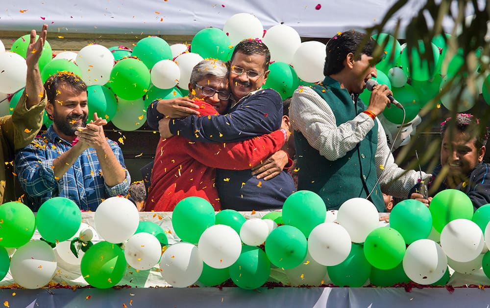 Aam Aadmi Party leaders Arvind Kejriwal and Ashutosh hug as they celebrate news of their party's performance in New Delhi.