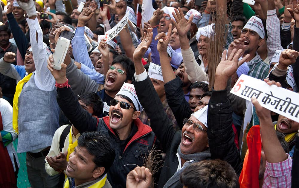 Supporters of the Aam Aadmi Party, celebrate as their party looks set for a landslide party in New Delhi,