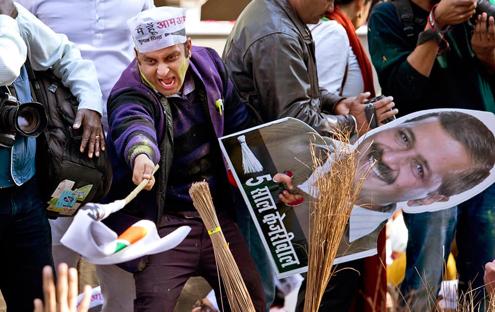 A supporter of Aam Aadmi Party holds a poster of party leader Arvind Kejriwal as he celebrates the party's victory in New Delhi.