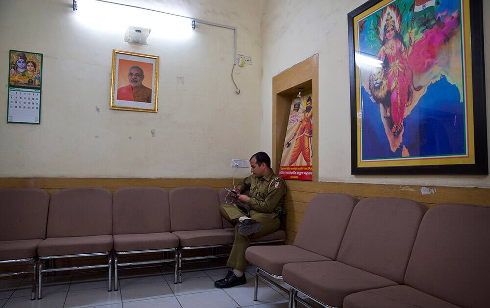 A lone policeman sits at the state headquarters of the Bharatiya Janata Party (BJP) in New Delhi.