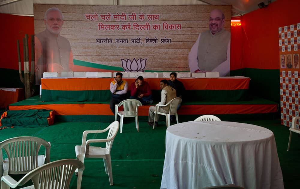 Members of Bharatiya Janata Party (BJP) sit near an empty stage set up for election result day at their party headquarters in New Delhi.