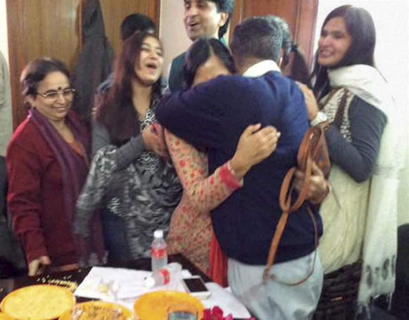 AAP convener Arvind Kejriwal hugs his wife as he celebrates his partys win in the Assembly polls, at his residence in Kaushambi.