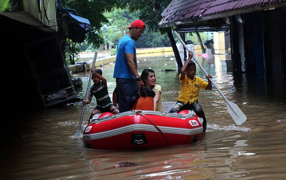 Residents use a rubber boat to make their way through a flooded neighborhood in Jakarta, Indonesia. Heavy downpour has caused flooding throughout the city.