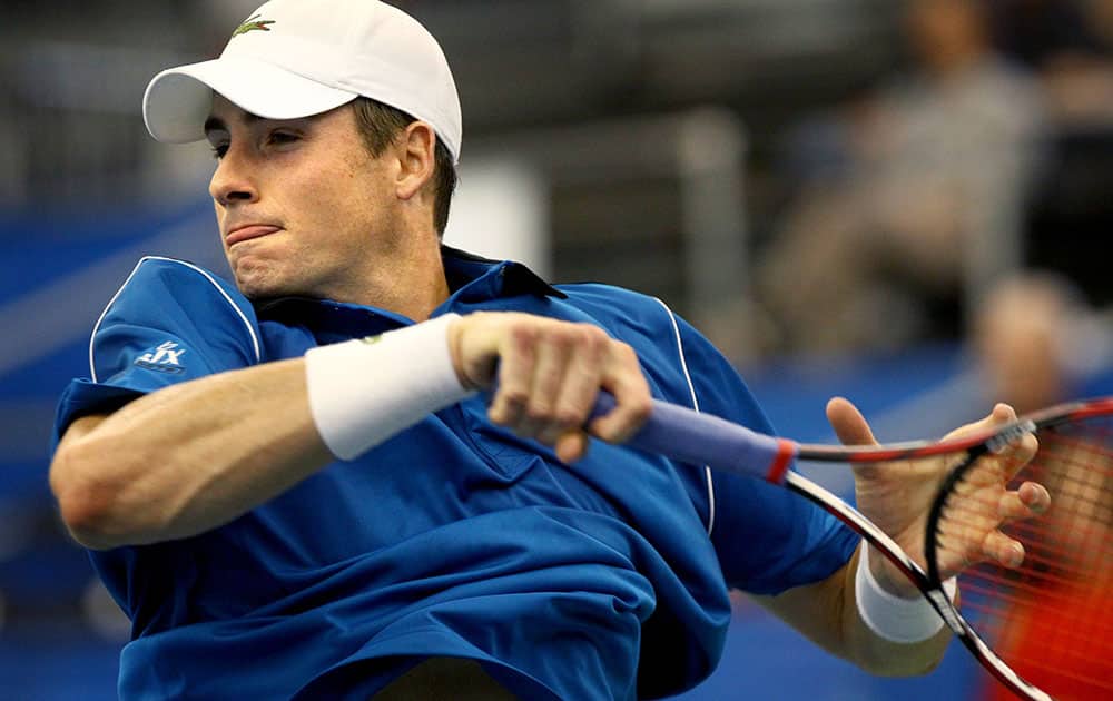 John Isner, of the United States, follows through on a return to Ivan Dodig, of Croatia, at the Memphis Open tennis tournament.