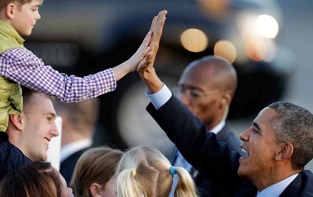 President Barack Obama high five's a boy upon his arrival at San Francisco International Airport, in San Francisco. 