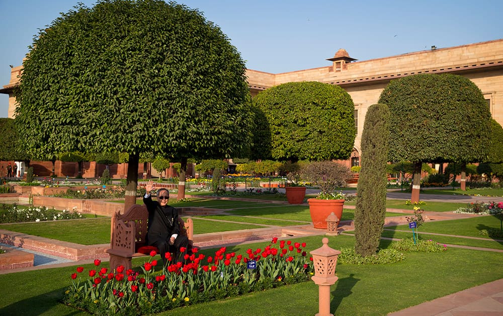 President Pranab Mukherjee waves as he sits on a bench of the Mughal Gardens surrounding the Indian Presidential palace during a press preview in New Delhi.