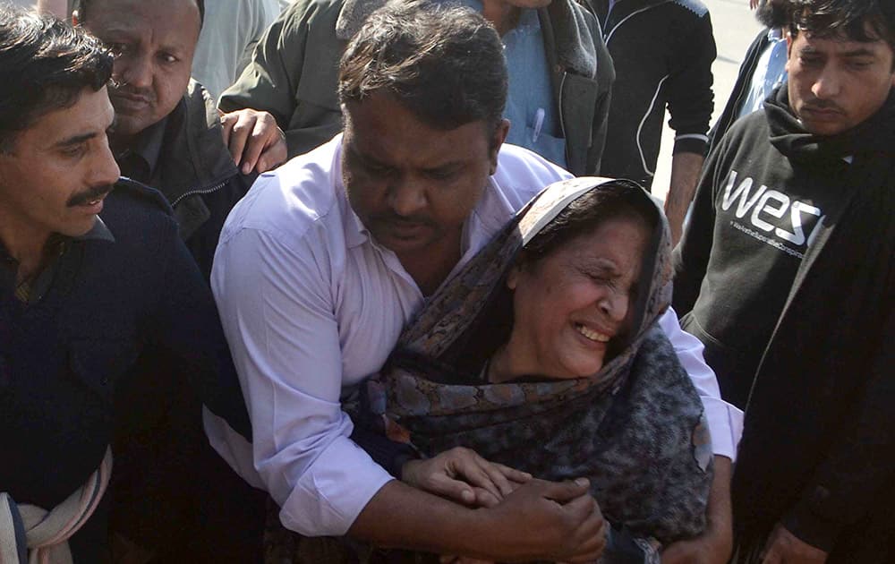 People comfort a woman who lost her family member following an attack involving suicide bombers and gunmen at a Shiite mosque, while at a local hospital in Peshawar, Pakistan.