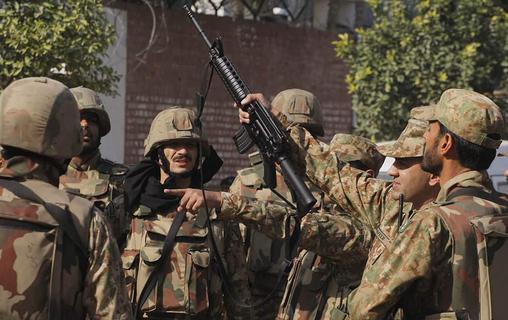 Pakistan army soldiers surround a Shiite mosque attacked by suicide bombers and gunmen in Peshawar, Pakistan.