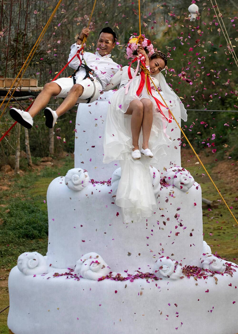 Groom, Chaiyut Phuamgphoeksuk and bride, Prontathorn Pronnapatthun jump from a 3.5 meter high wedding cake, as a part of an adventure-themed wedding ceremony in Ratchaburi Province, Thailand, on the eve of Valentine's Day. 