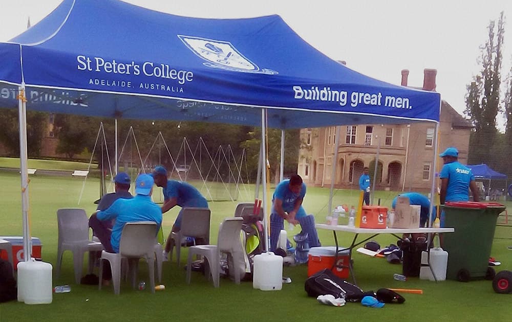 Indian cricket players relax after training session at St Peters College ground in Adelaide.