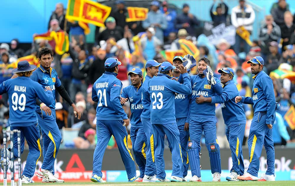 Sri Lanka's Suranga Lakmal and Kumar Sangakkara, celebrate with teammates after combining to take the wicket of New Zealand's Martin Guptill for 49 runs during the opening match of the Cricket World Cup at Christchurch, New Zealand.