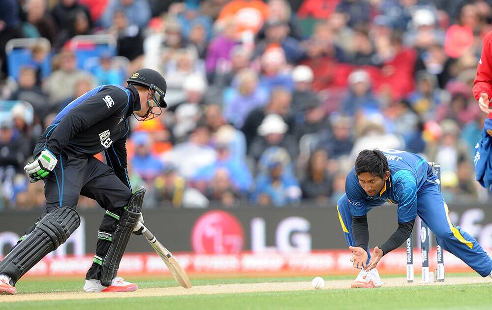 Sri Lanka's Jeevan Mendis, fields the ball as New Zealand's Martin Guptill, reaches to return to his crease during the opening match of the Cricket World Cup at Christchurch, New Zealand.