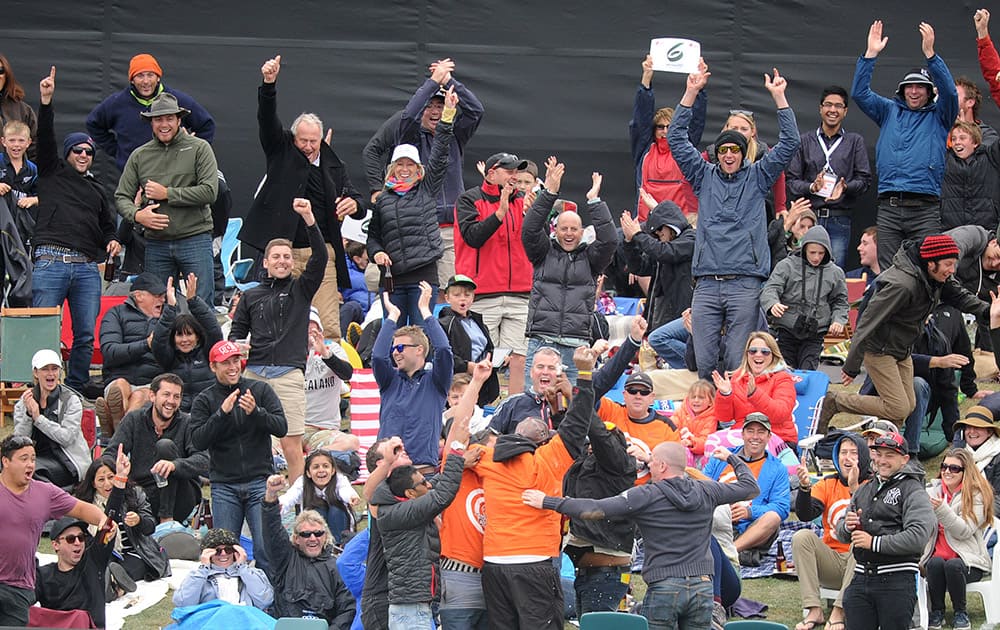 The crowd celebrate after a fan, bottom center with back to the camera, made a one-handed catch off a six hit by New Zealand against Sri Lanka during the opening match of the Cricket World Cup at Christchurch, New Zealand.