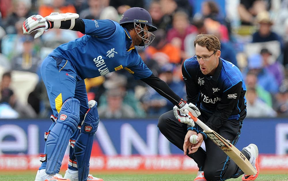 New Zealand's Daniel Vettori, right, catches out, off his own bowling, Sri Lanka's Tillakaratne Dilshan for 24 runs as Lahiru Thirimanne, left, reaches for his crease during the opening match of the Cricket World Cup at Christchurch, New Zealand.