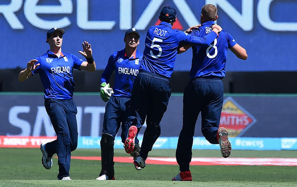 England cricketer, Chris Woakes, Jos Buttler, Joe Root, Stuart Broad celebrate after taking the wicket of Australia batsman David Warner during their cricket world cup pool A match in Melbourne.