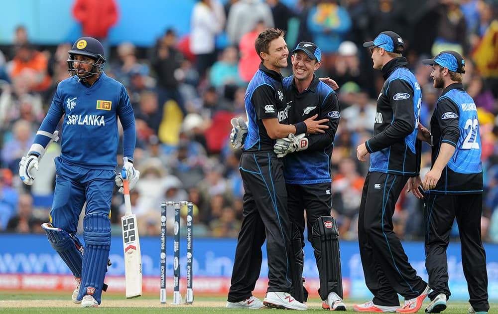 Sri Lanka's Kumar Sangakkara, left, begins to walk off after losing his wicket LBW for 39 runs to New Zealand's Trent Boult, second left, during the opening match of the Cricket World Cup at Christchurch, New Zealand.