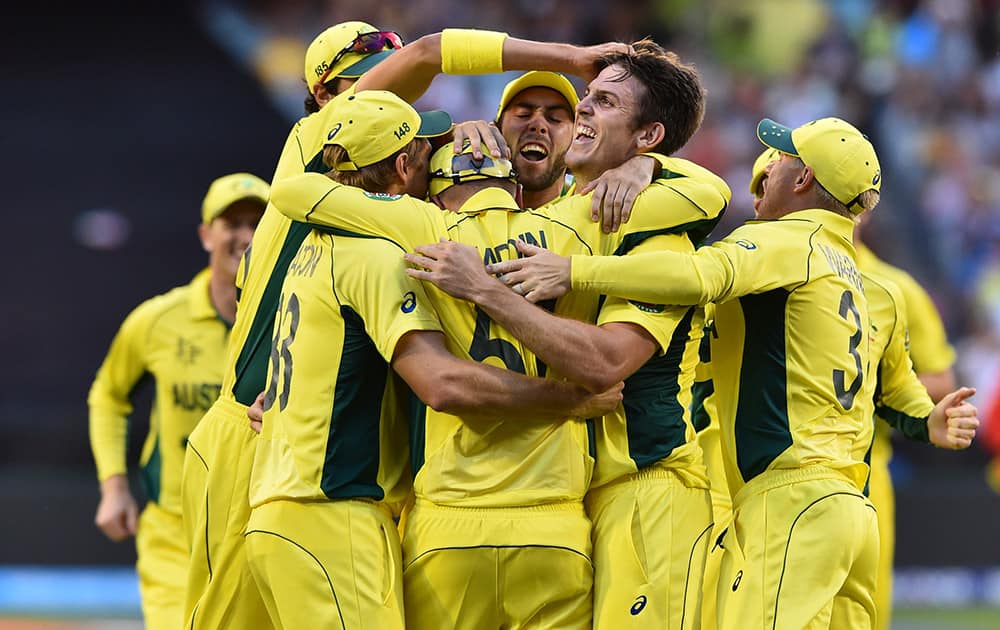 Australia's Mitchell Marsh is congratulated by team mates after taking the wicket of England’s captain Eoin Morgan during their Cricket World Cup pool A match in Melbourne, Australia.