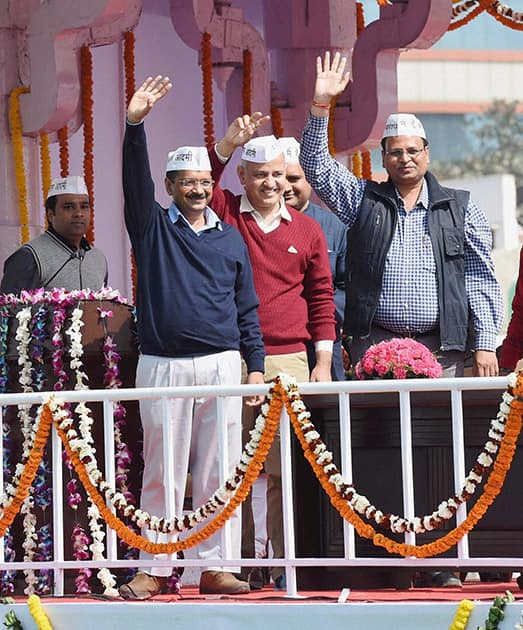 Delhi Chief Minister Arvind Kejriwal and cabinet ministers wave at supporters during the oath taking ceremony at Ramlila maidan in New Delhi.