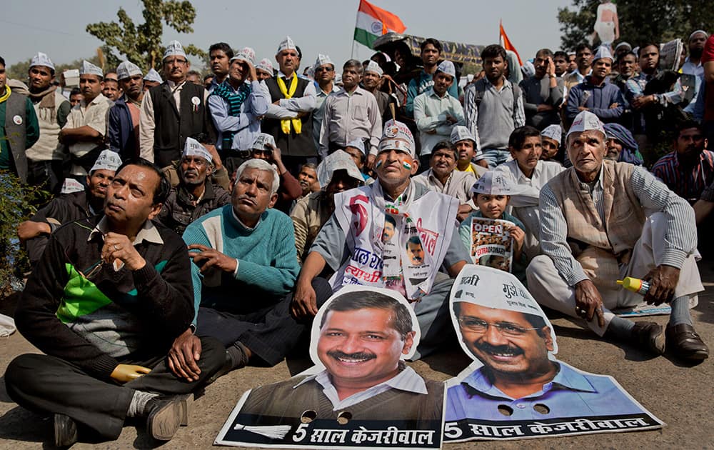 Supporters of the Aam Aadmi Party, follows on a giant screen the oath-taking ceremony of party leader Arvind Kejriwal as the new Chief Minister of Delhi, in New Delhi.