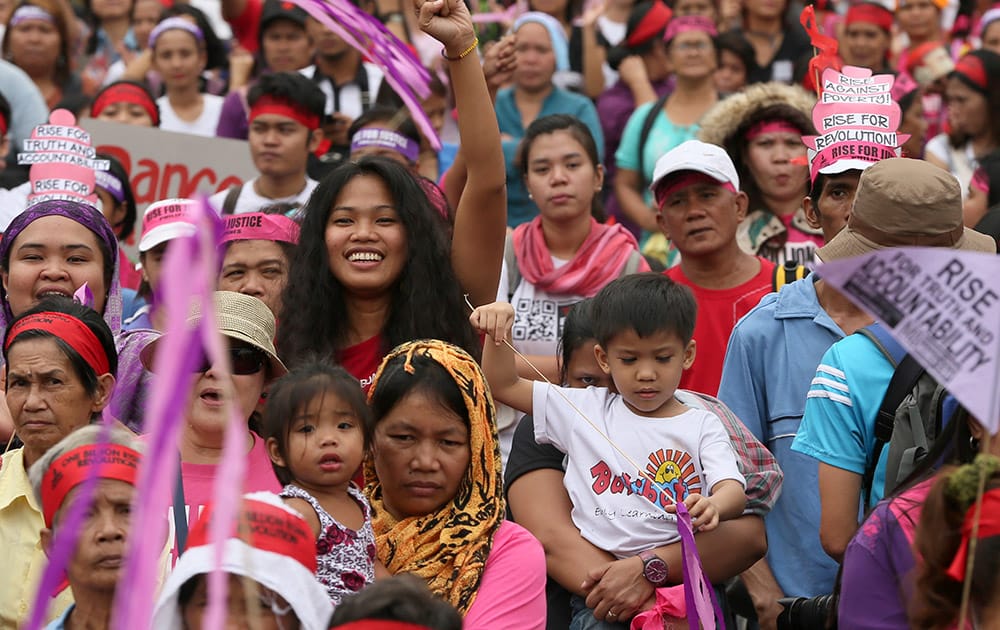 Protesters carry their children during a rally for a global campaign to end violence against women and children, dubbed One Billion Rising in Manila, Philippines. 