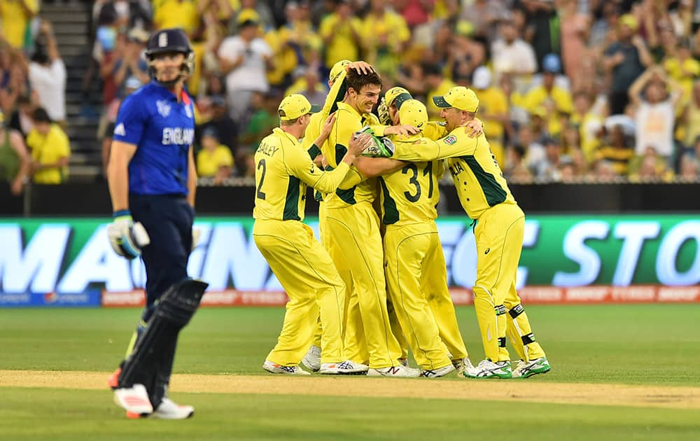 England's Jos Buttler walks off the field past Australia's Mitchell Marsh, as he celebrates with team mates during their Cricket World Cup pool A match in Melbourne, Australia.