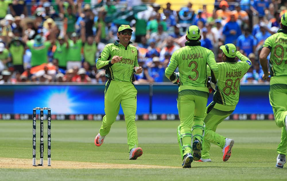 Pakistan captain Misbah-ul-Haq, left, rushes to celebrate after taking a catch to dismiss India's Rohit Sharma during the World Cup Pool B match in Adelaide.