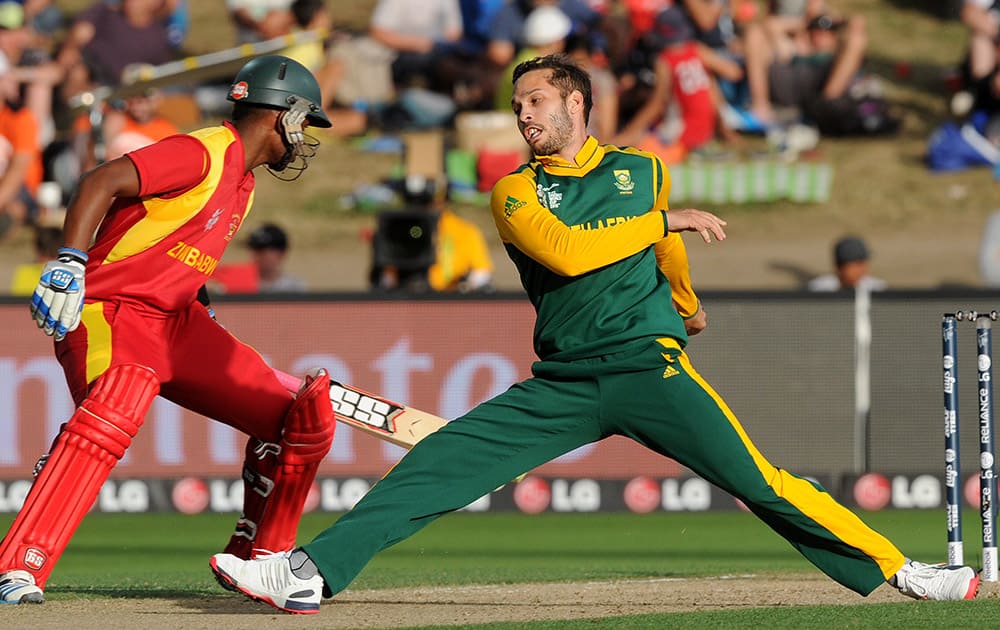 South Africa's Farhaan Behardien, stretches while attempting to field as Zimbabwe's Chamu Chibhabha, returns to his crease during their Cricket World Cup pool B match at Hamilton, New Zealand.