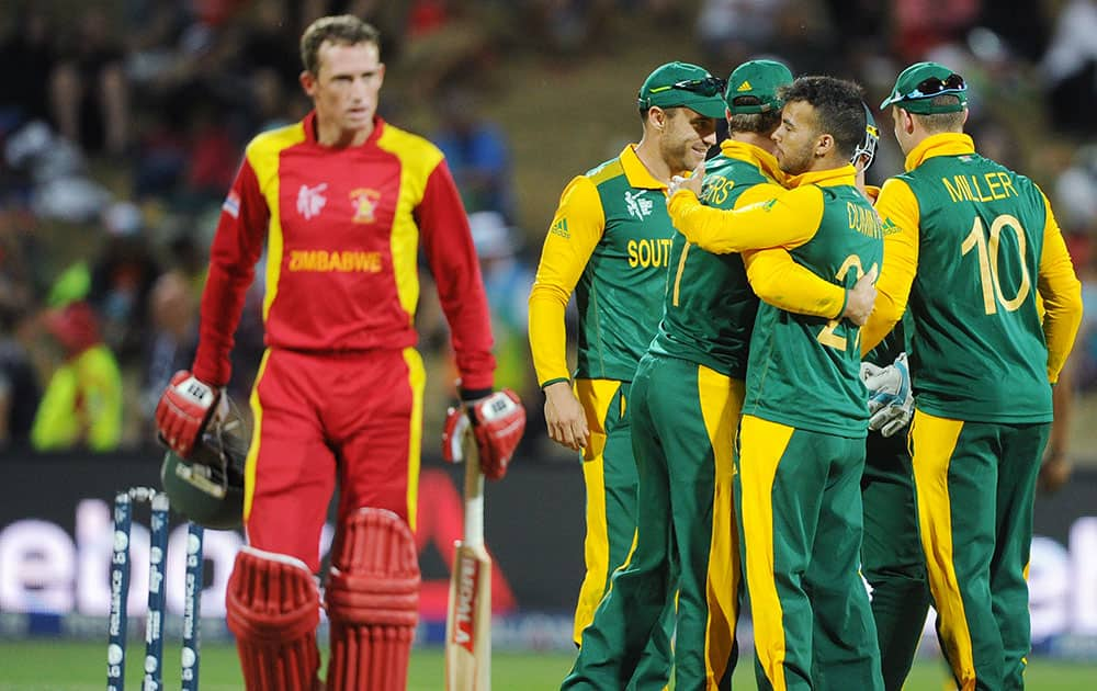 Zimbabwe's Sean Williams, leaves the field after he is caught out for 8 runs as South African teammates celebrate during their Cricket World Cup pool B match at Hamilton, New Zealand.