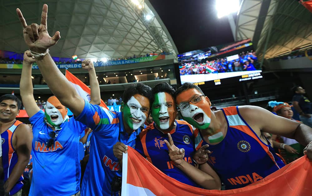 Indian cricket fans, face painted with colors of the Indian flag react to the camera after India won the World Cup Pool B match against Pakistan in Adelaide, Australia.