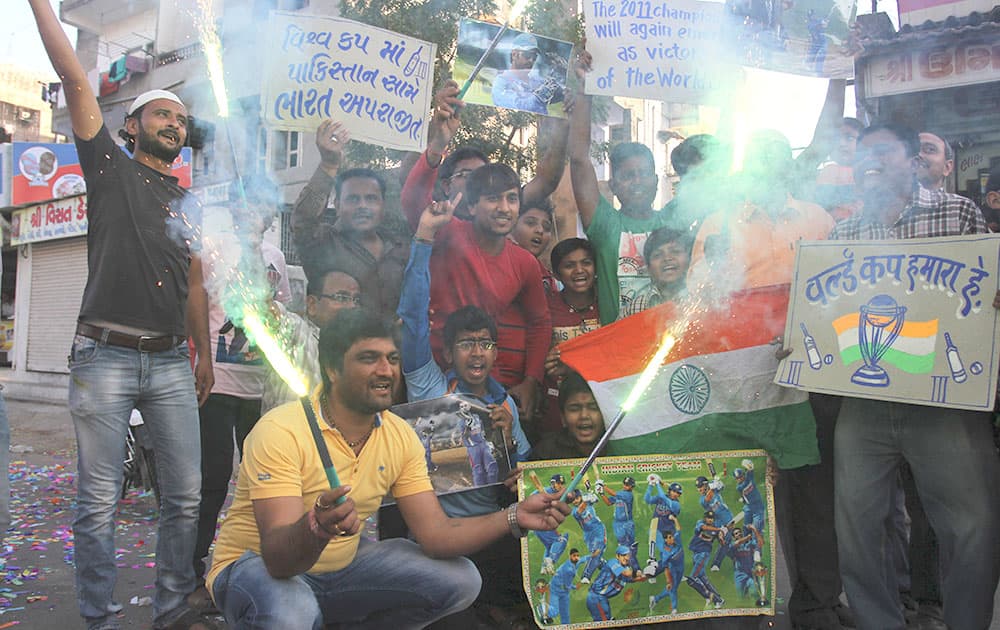 Cricket fans pose for the media after India won Sunday's World Cup Pool B match against Pakistan at the Adelaide Oval as they celebrate in Ahmadabad