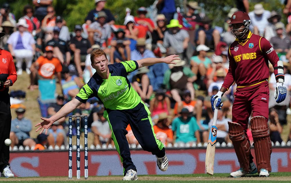 Ireland's Kevin O'Brien, left, reaches to field a ball off his own bowling as West Indies' Marlon Samuels holds his ground during their Cricket World Cup pool B match at Nelson, New Zealand.