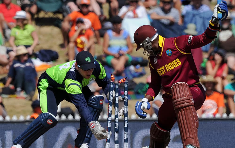 Ireland's wicketkeeper Gary Wilson, left, attempts a stumping on West Indies' Marlon Samuels during their Cricket World Cup pool B match at Nelson, New Zealand.