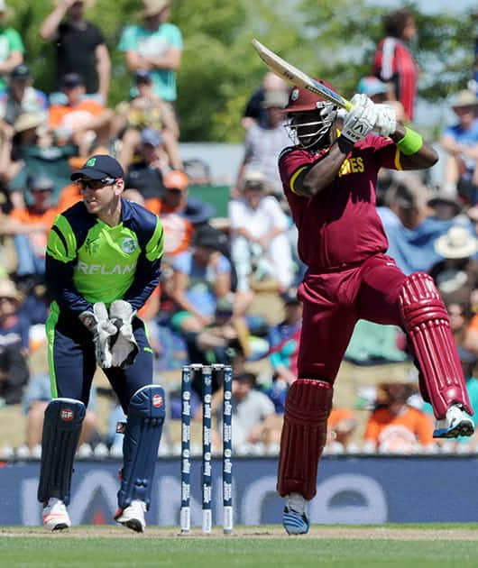 West Indies' Darren Sammy, right, drives the ball as Ireland's wicketkeeper Gary Wilson readies to field during their Cricket World Cup pool B match at Nelson, New Zealand.