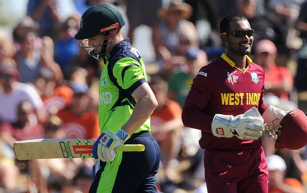 Ireland's William Porterfield, left, begins to walk off the field after he is caught out for 23 runs by West Indies's Denesh Ramdin, right, during their Cricket World Cup pool B match at Nelson, New Zealand.