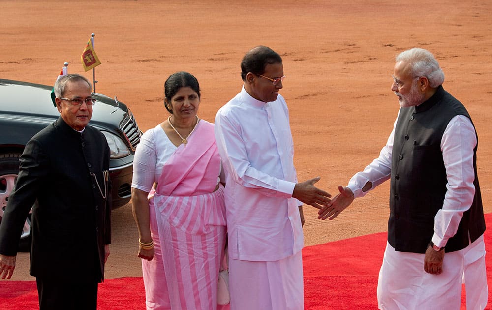 Prime Minister Narendra Modi, shakes hands with Sri Lanka's President Maithripala Sirisena, as his wife Jayanthi Sirisena, and President Pranab Mukherjee watch during a ceremonial reception at the Indian presidential palace in New Delhi.