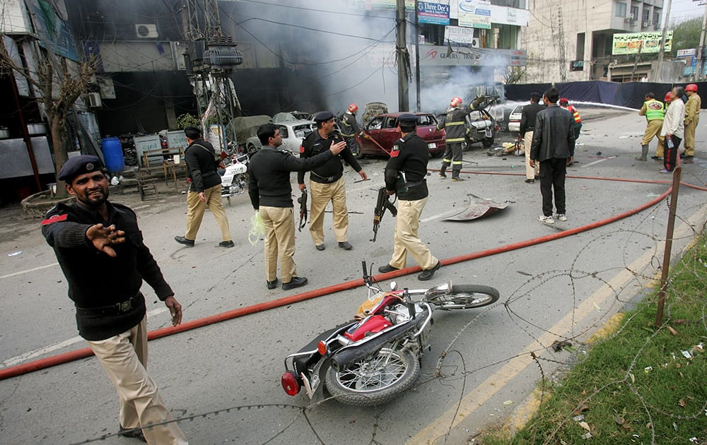 Pakistani police officers cordon off the site of a bombing in Lahore, Pakistan. An apparent suicide bombing killed many people outside a police complex in eastern Pakistan, officials said, in a rare attack on the relatively peaceful city of Lahore.