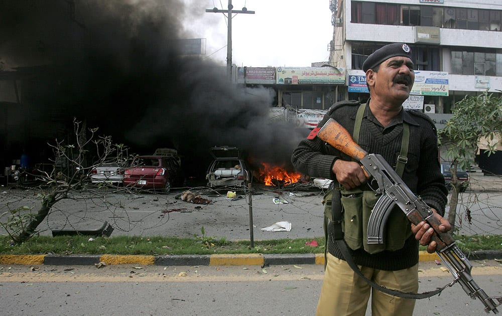 A Pakistani police officer stands guard at the site of bombing in Lahore, Pakistan.